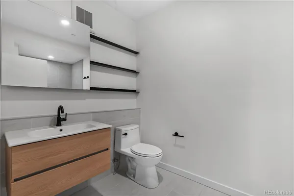 a bathroom with a toilet a sink and mirror