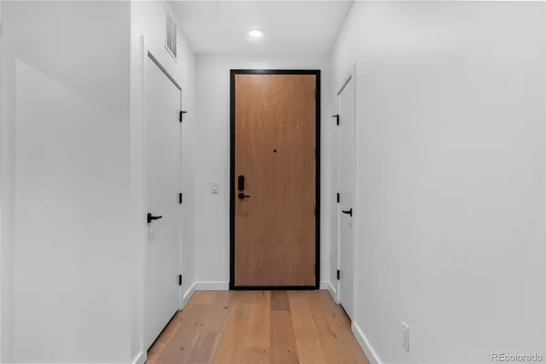a view of a hallway with wooden floor and closet