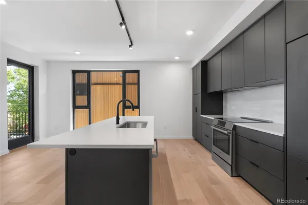 a kitchen with kitchen island a sink appliances cabinets and a large window