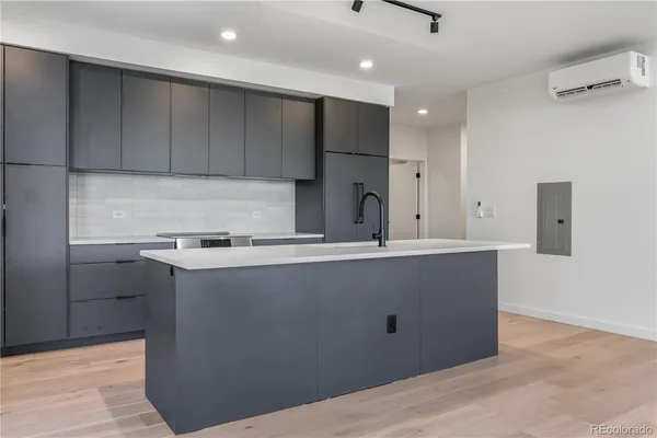 a kitchen with kitchen island a sink a stove and a refrigerator