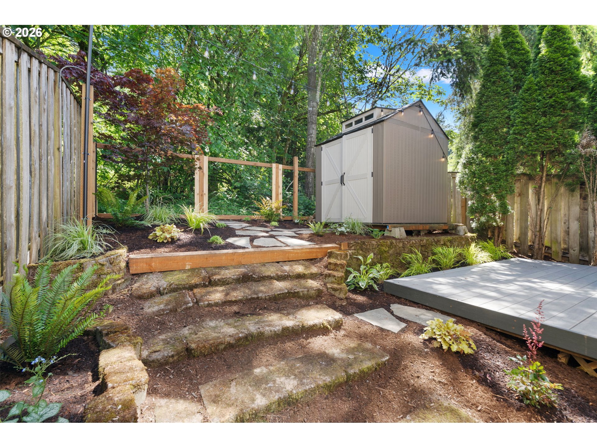 13159 Southwest Brianne Way Portland, OR 97223 - Photo 29 of 32 a backyard of a house with plants and trees with wooden fence