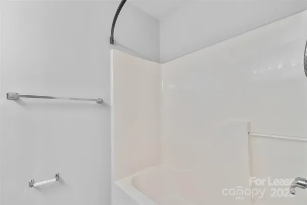a bathroom with a white bath tub and a shower