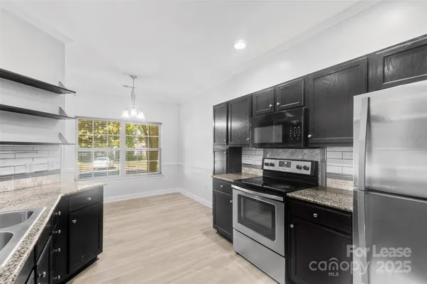 a kitchen with granite countertop a refrigerator and a stove