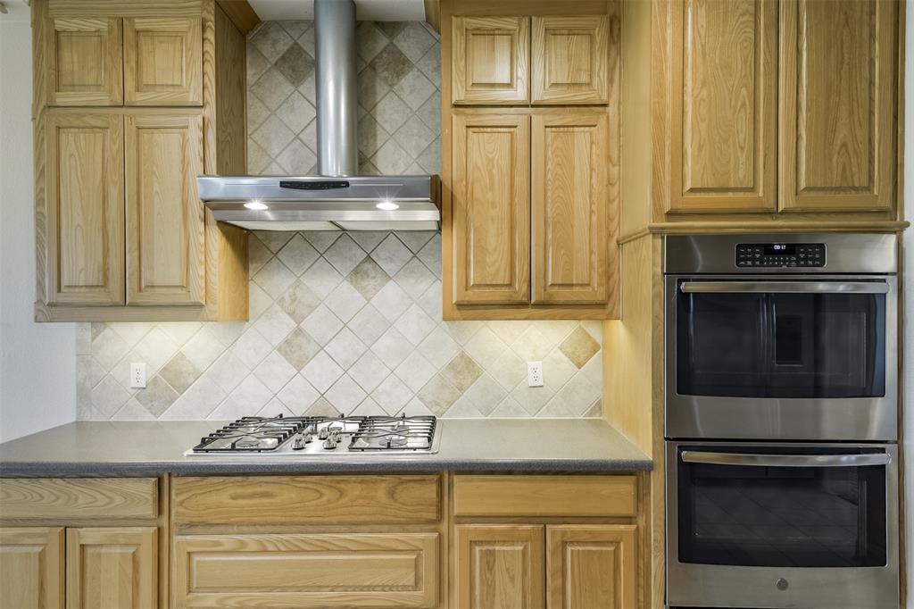 1066 W Road Waxahachie, TX 75165 - Photo 12 of 36 a kitchen with granite countertop white cabinets and stainless steel appliances