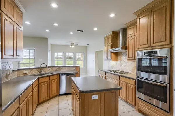 a kitchen with stainless steel appliances granite countertop a sink stove and cabinets
