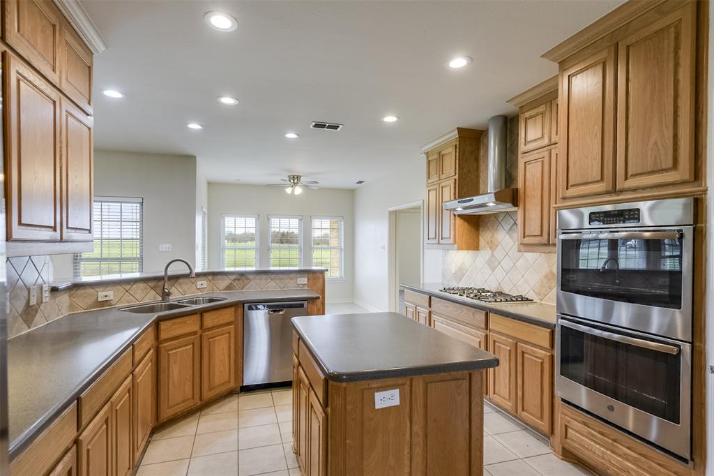 1066 W Road Waxahachie, TX 75165 - Photo 13 of 36 a kitchen with stainless steel appliances granite countertop a sink stove and cabinets