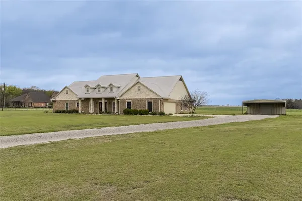 a front view of a house with a big yard