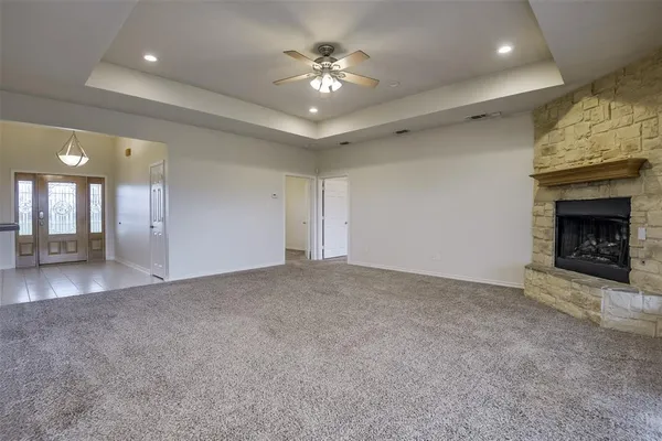 a view of an empty room and chandelier fan