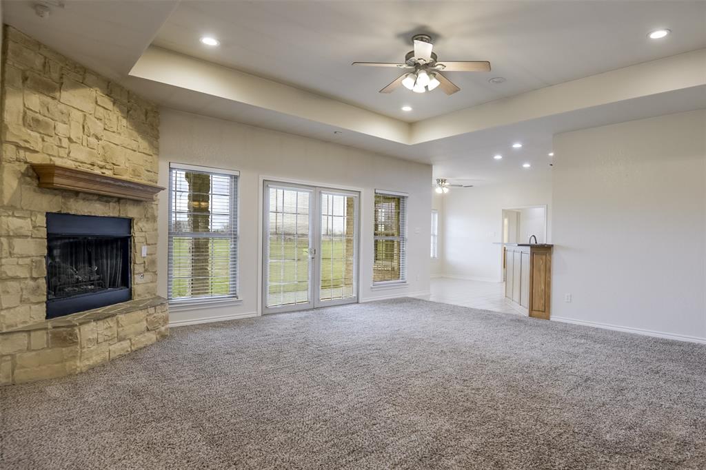 1066 W Road Waxahachie, TX 75165 - Photo 9 of 36 a view of an empty room with a fireplace and a ceiling fan