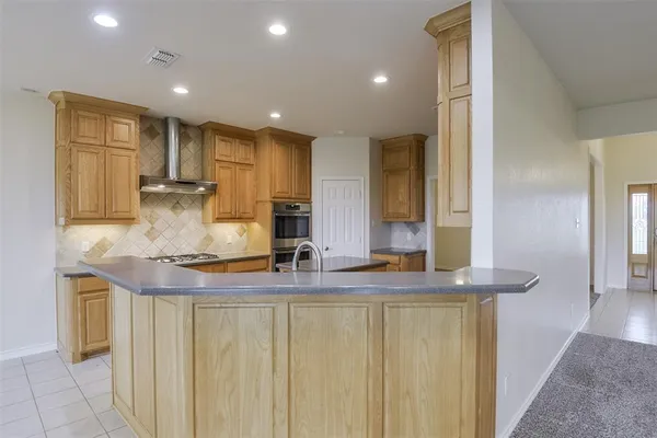 a kitchen with kitchen island granite countertop counter top space a sink stainless steel appliances and cabinets