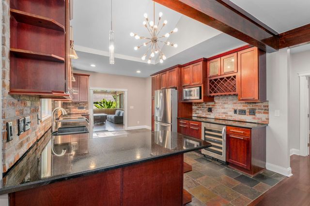 a kitchen with stainless steel appliances granite countertop a sink stove and refrigerator