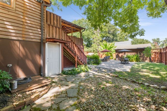 a view of patio with chairs and table under an umbrella