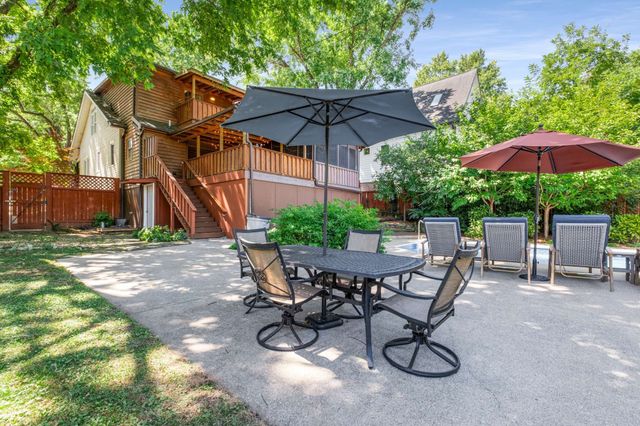 a view of a patio with table and chairs under an umbrella