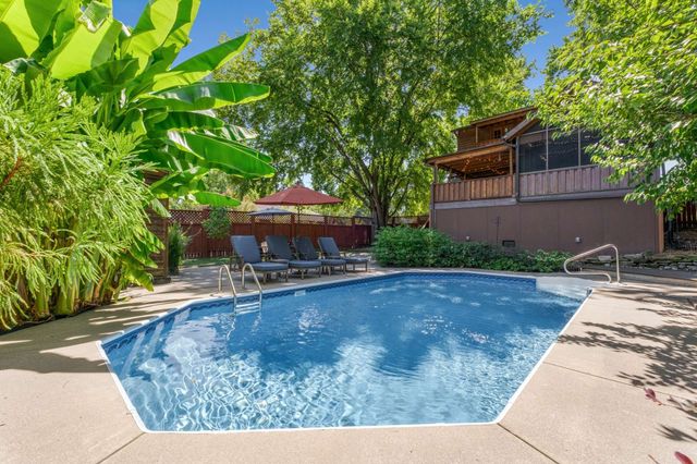 a view of a backyard with table and chairs under an umbrella
