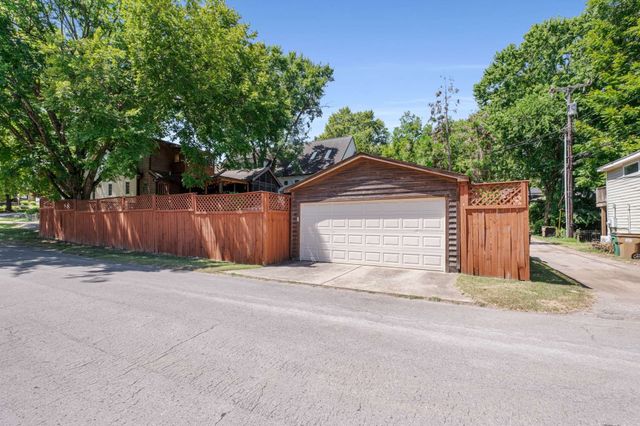 a front view of house with yard and trees in the background