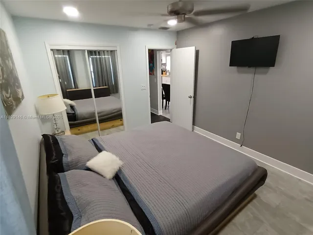 a bedroom with double bed and a painting on the wall