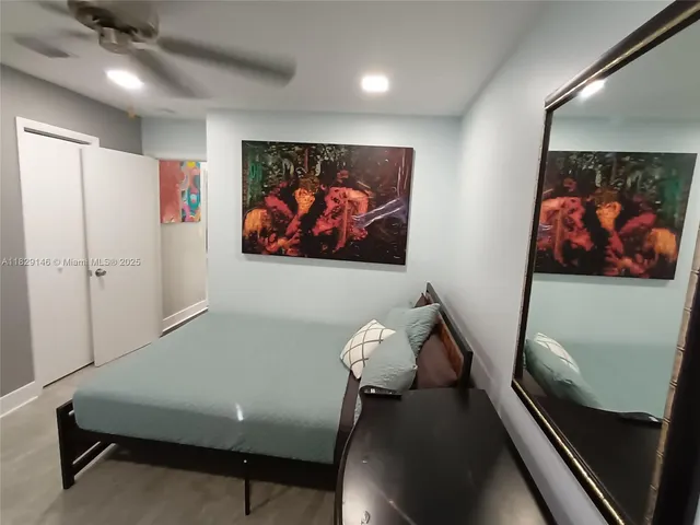 a view of an empty room with wooden floor and a flat screen tv