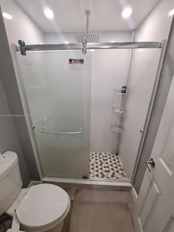 a bedroom with a bed a mirror on dresser and a chandelier