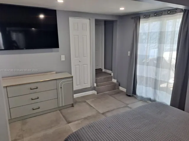 a bed room with a bed tv and a chair