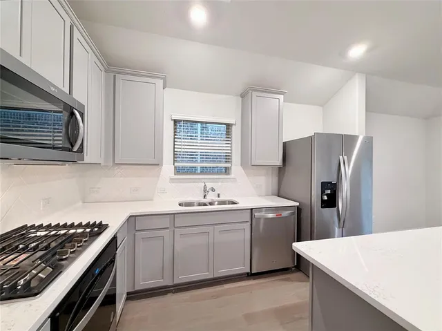 a kitchen that has a sink a stove and refrigerator