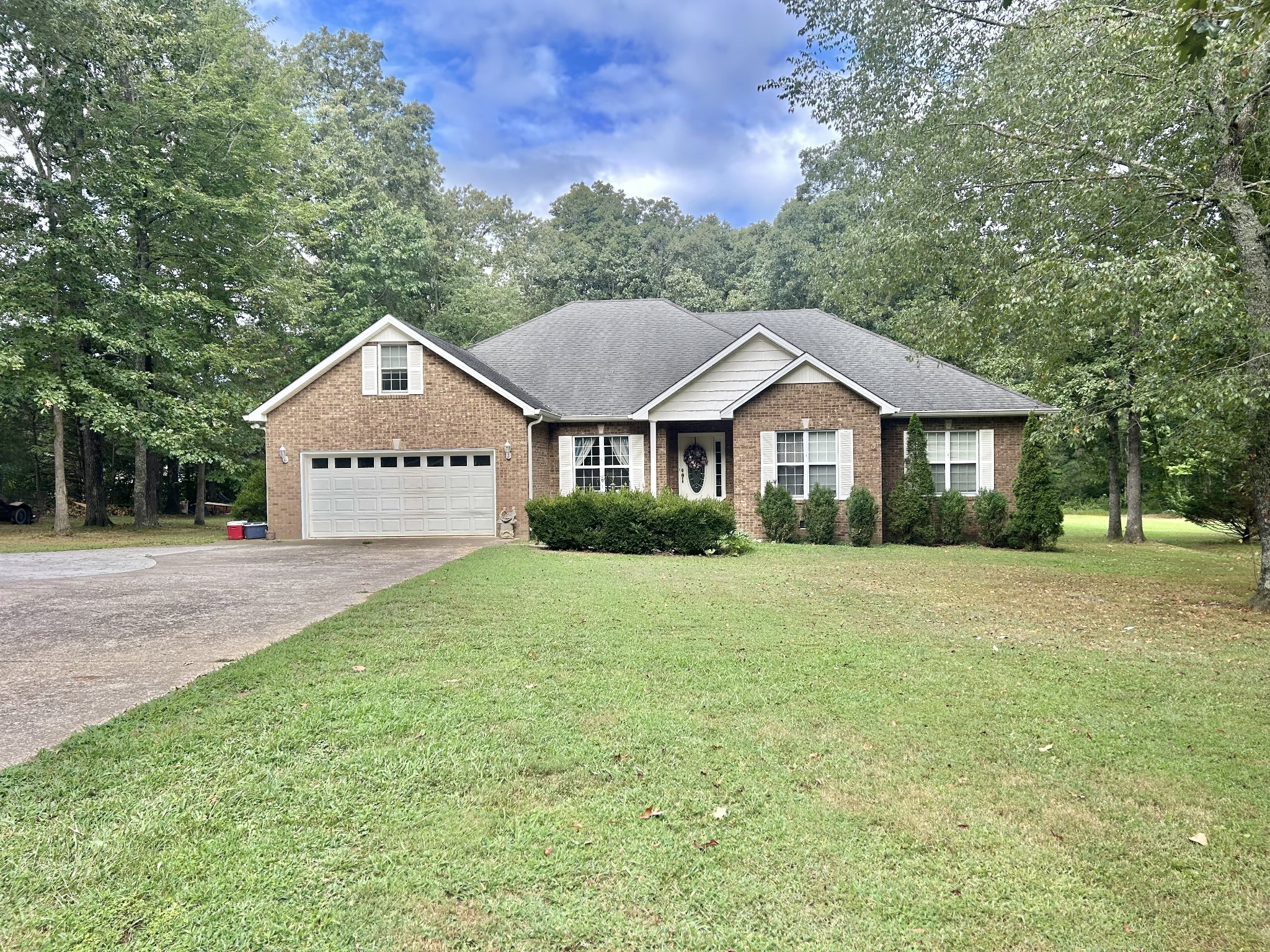 a front view of a house with a yard and trees