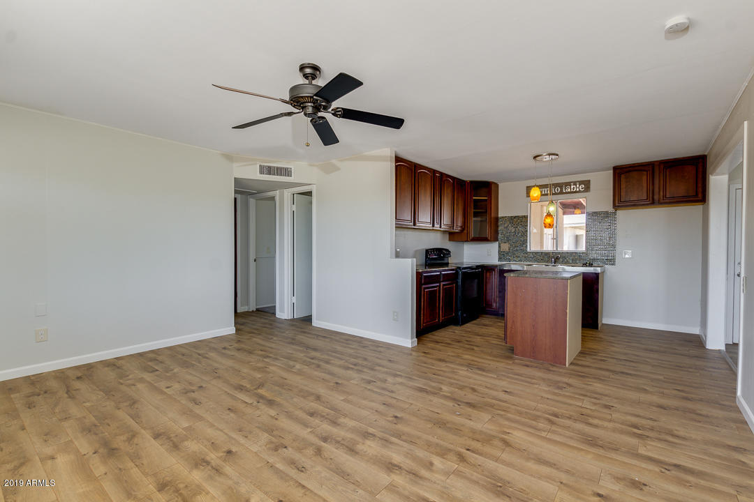 20632 West Telegram Path Road Buckeye, AZ 85326 - Photo 7 of 23 a kitchen with stainless steel appliances kitchen island granite countertop a stove top oven and sink