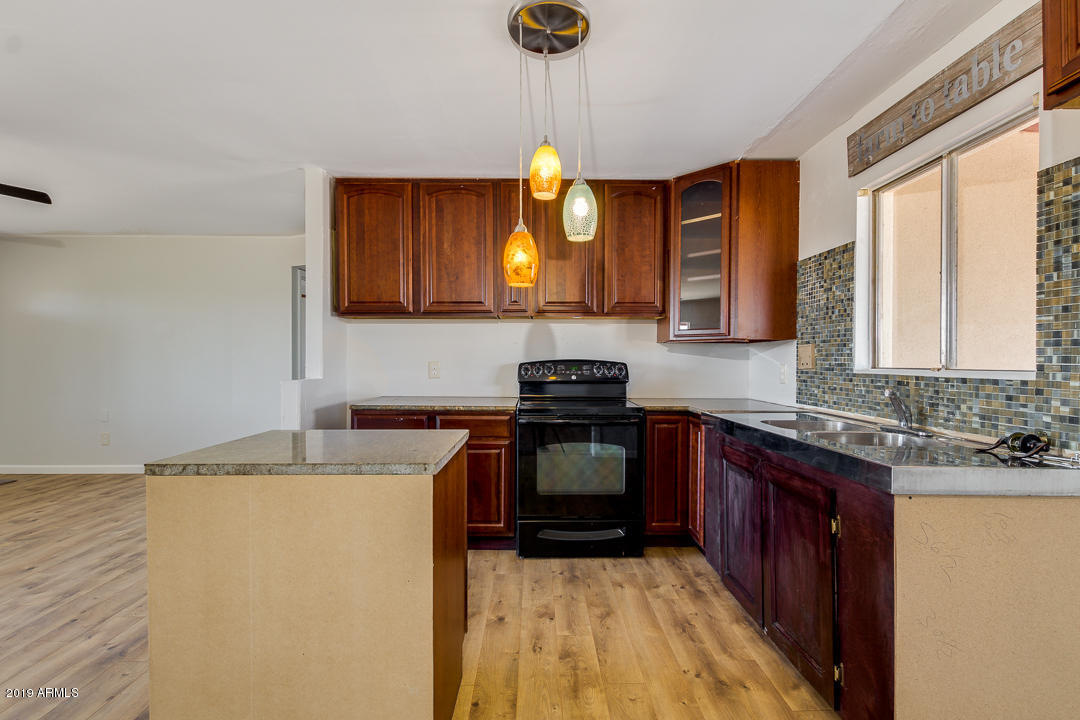 20632 West Telegram Path Road Buckeye, AZ 85326 - Photo 10 of 23 a kitchen with a sink a stove cabinets and a wooden floor