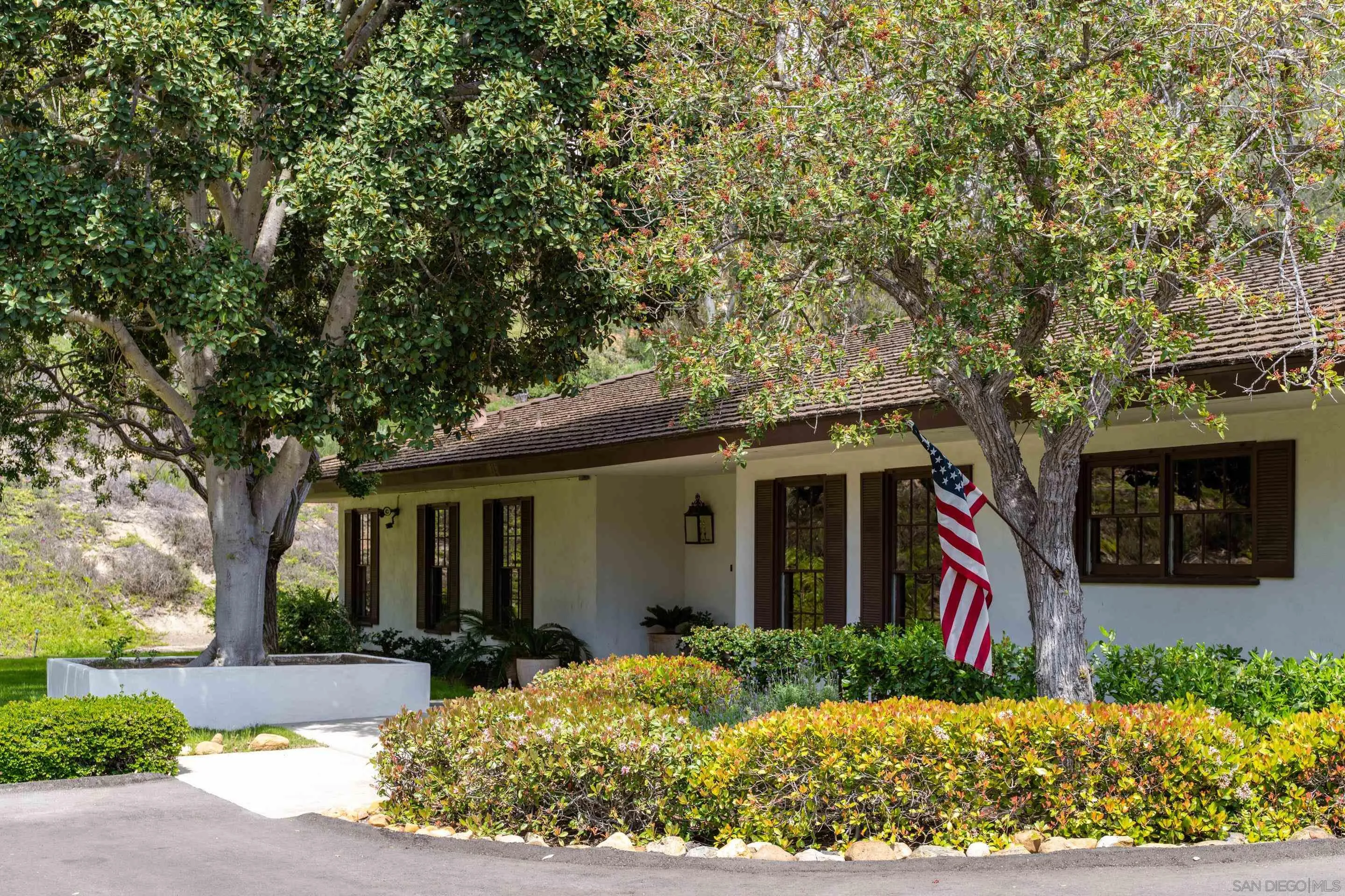 a front view of a house with a yard and potted plants