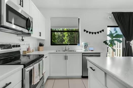 11852 Southwest 245 Terrace Homestead, FL 33032 - Photo 7 of 31 a kitchen with stainless steel appliances a sink stove and microwave