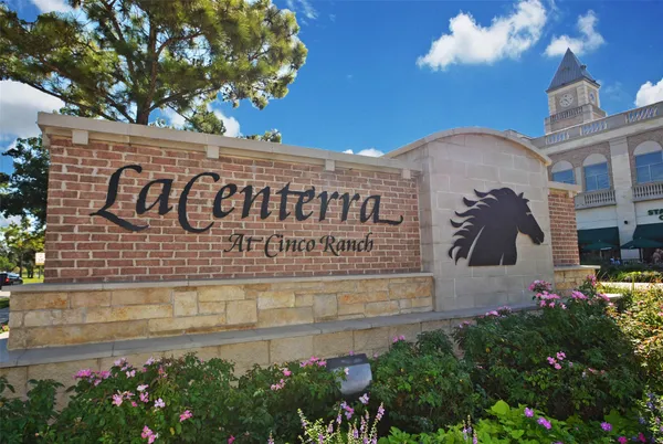 a view of sign board with buildings in background