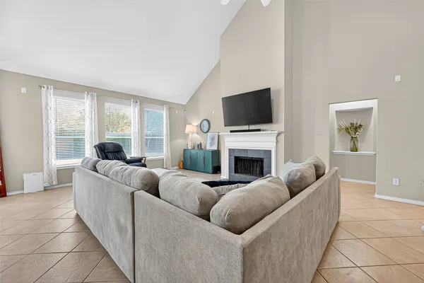 a living room with furniture a fireplace and a flat screen tv