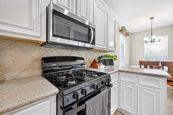 a kitchen with stainless steel appliances granite countertop a stove and a microwave
