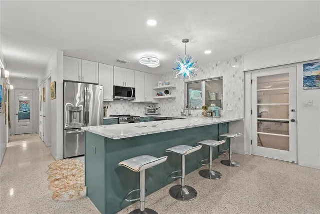 a kitchen with kitchen island cabinets and refrigerator