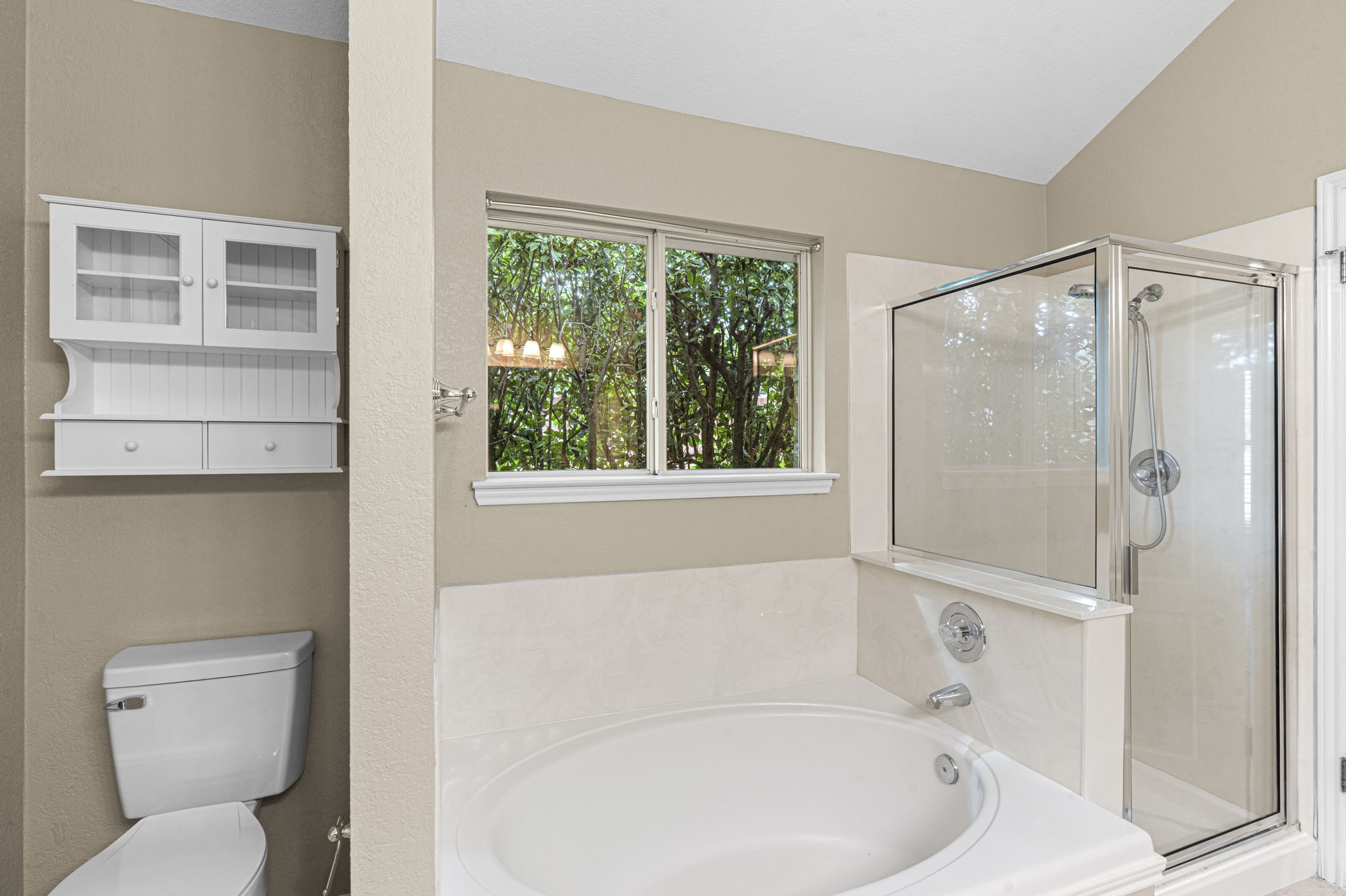 7172 Ridge Oak Road Austin, TX 78749 - Photo 32 of 40 A spacious bathroom offers a large soaking tub and a glass-enclosed shower, perfect for relaxation.