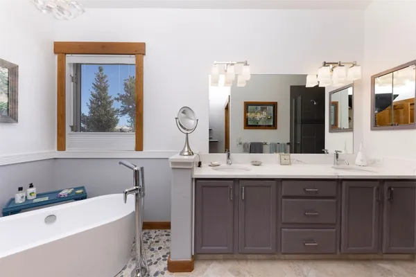 a bathroom with a tub a sink and mirror