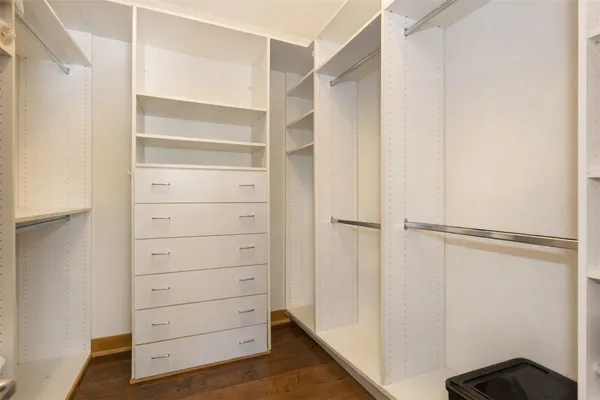 a view of walk in closet with empty racks