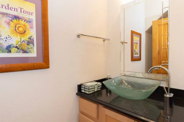 a bathroom with a granite countertop sink and a mirror