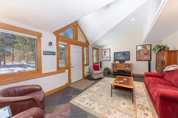 a living room with furniture a rug and a large window
