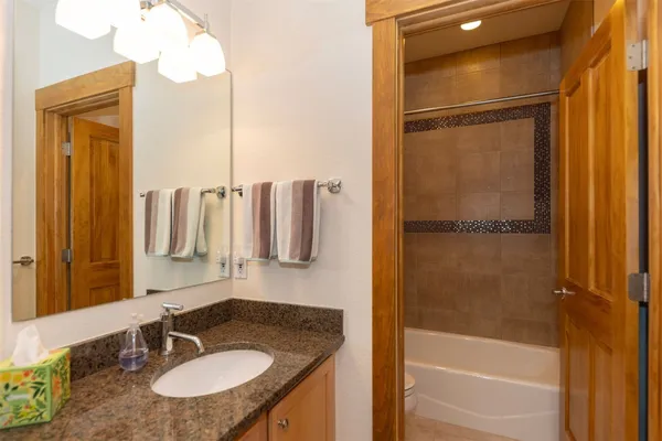 a bathroom with a granite countertop sink and a mirror