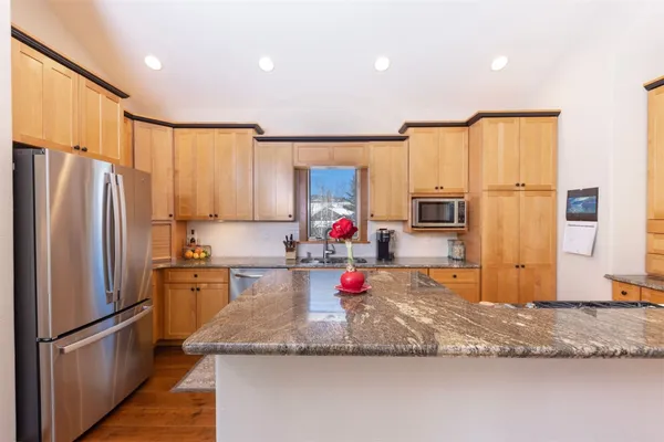 a kitchen with stainless steel appliances granite countertop a refrigerator sink and cabinets
