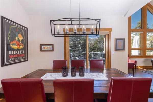 a view of a dining room with furniture a chandelier and window