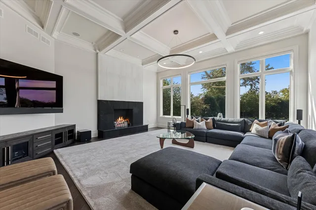 a living room with furniture a large window and a flat screen tv