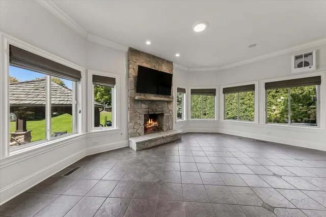 a view of an empty room with a window and fire place