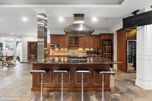 a kitchen with stainless steel appliances granite countertop a stove top oven a sink and a refrigerator