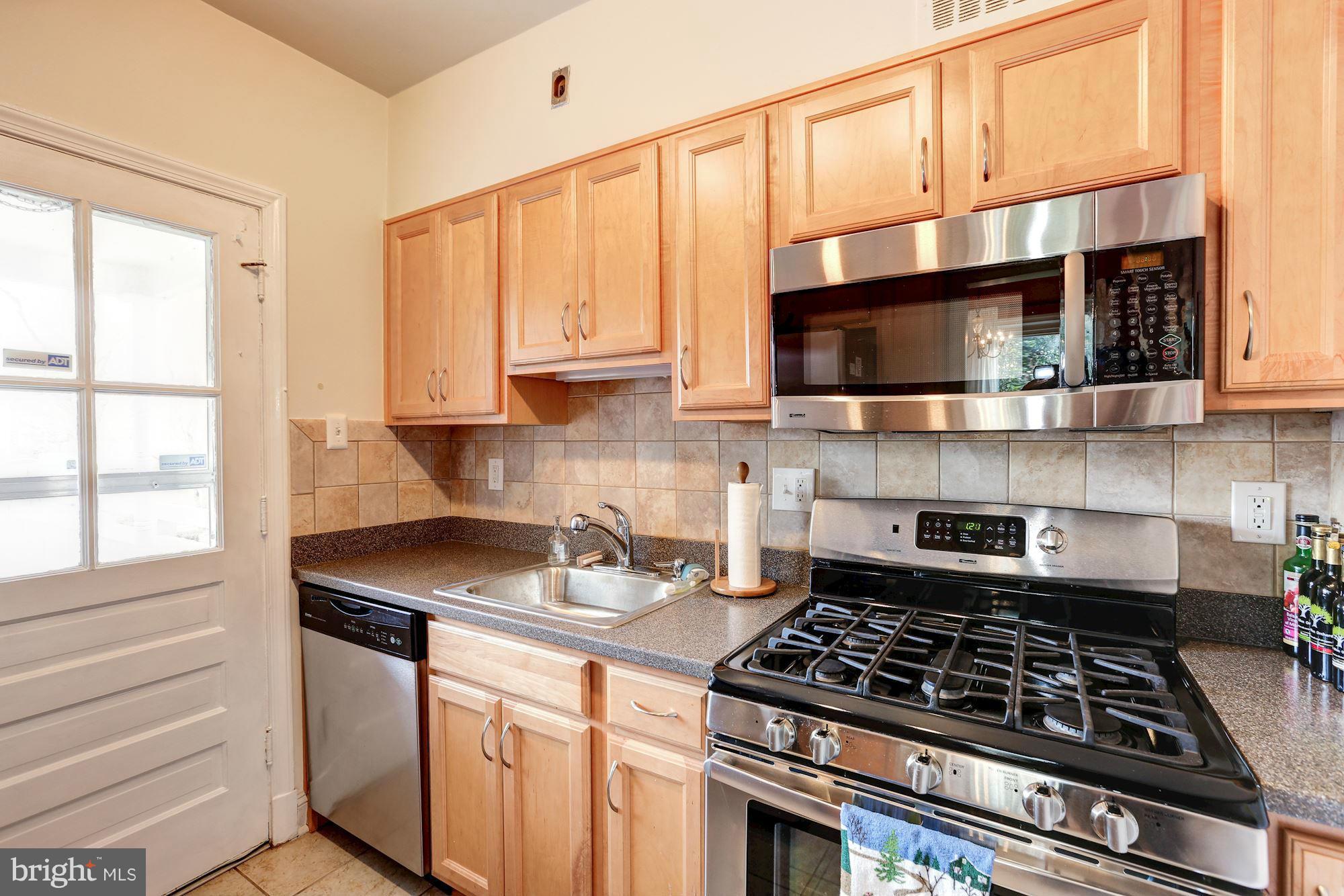 10002 Rogart Road Silver Spring, MD 20901 - Photo 9 of 28 a kitchen with stainless steel appliances a stove a sink and a microwave