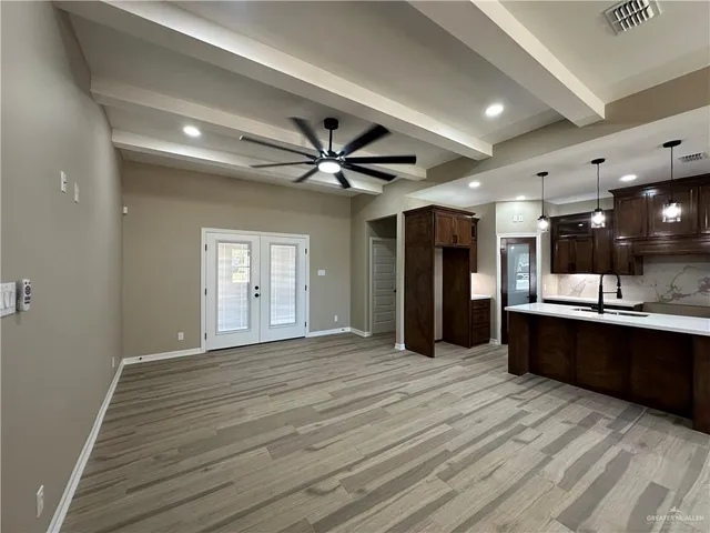 a view of an empty room with lot of kitchen