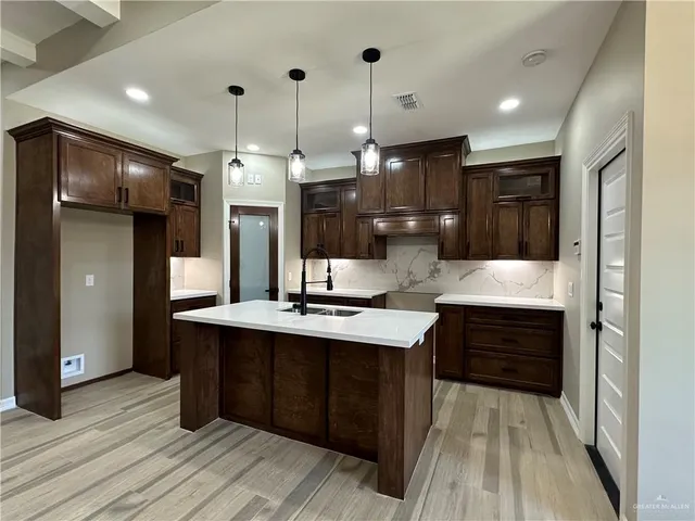 a view of an empty room with window and a kitchen