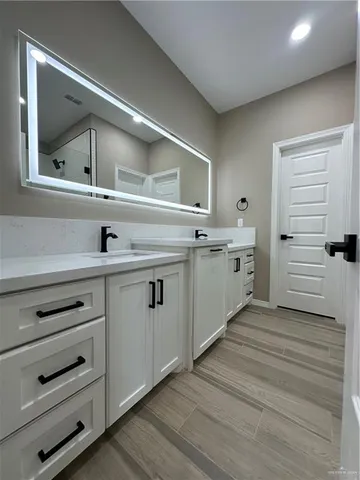 an empty room with wooden floor chandelier fan and windows