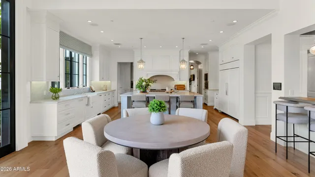 a kitchen with a table chairs sink and cabinets