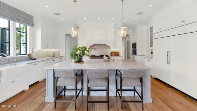 a view of cabinets a window and a potted plant on the wooden floor
